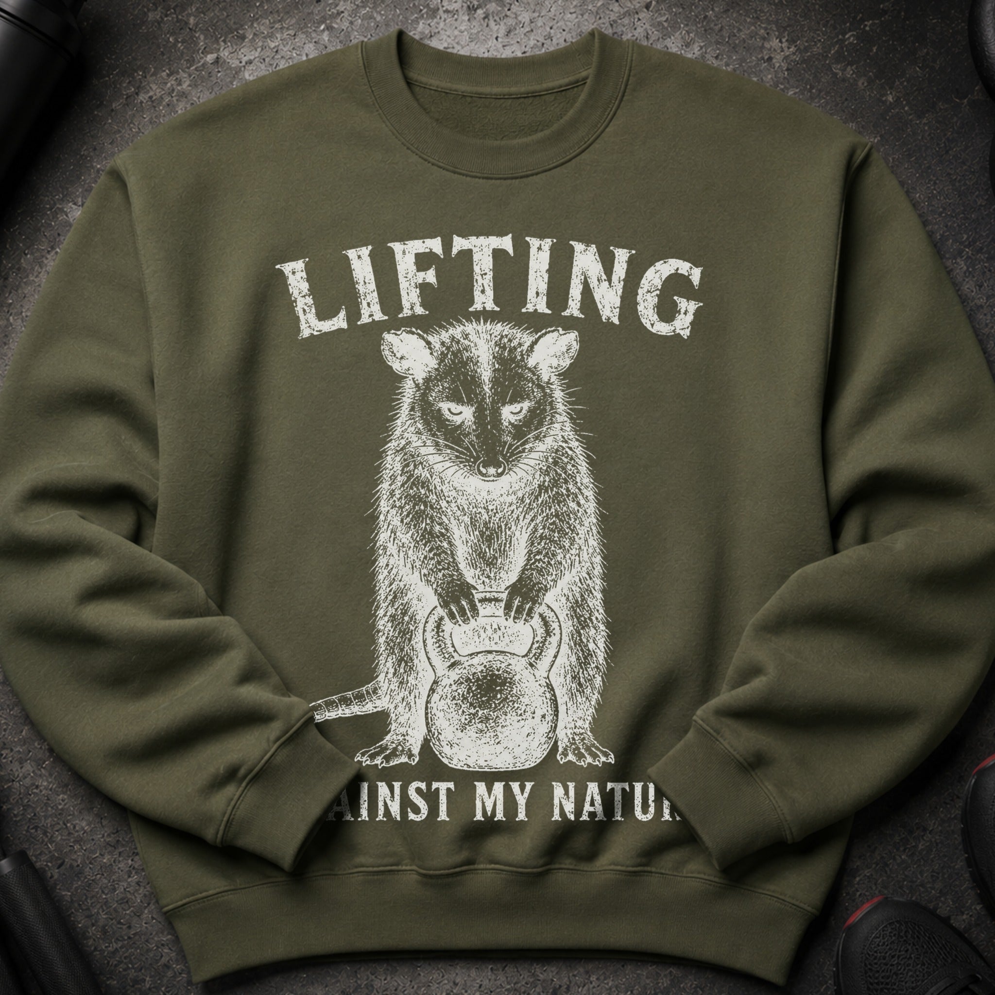 Olive sweatshirt with raccoon graphic and text "LIFTING AGAINST MY NATU".