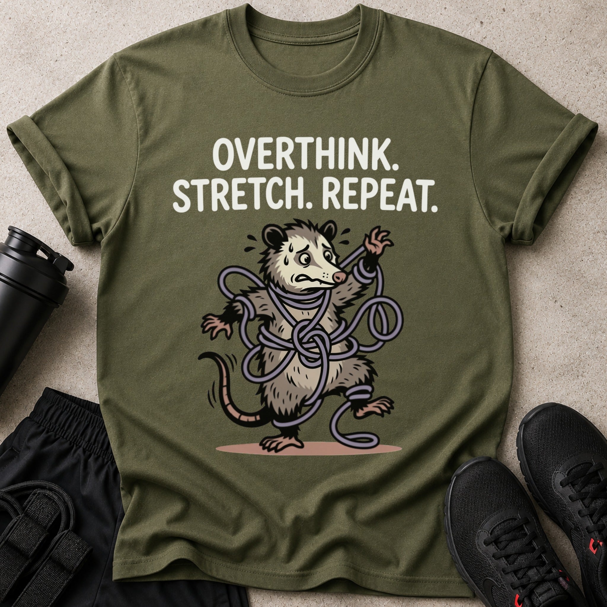Green t-shirt with "OVERTHINK. STRETCH. REPEAT." and a possum tangled in straps.