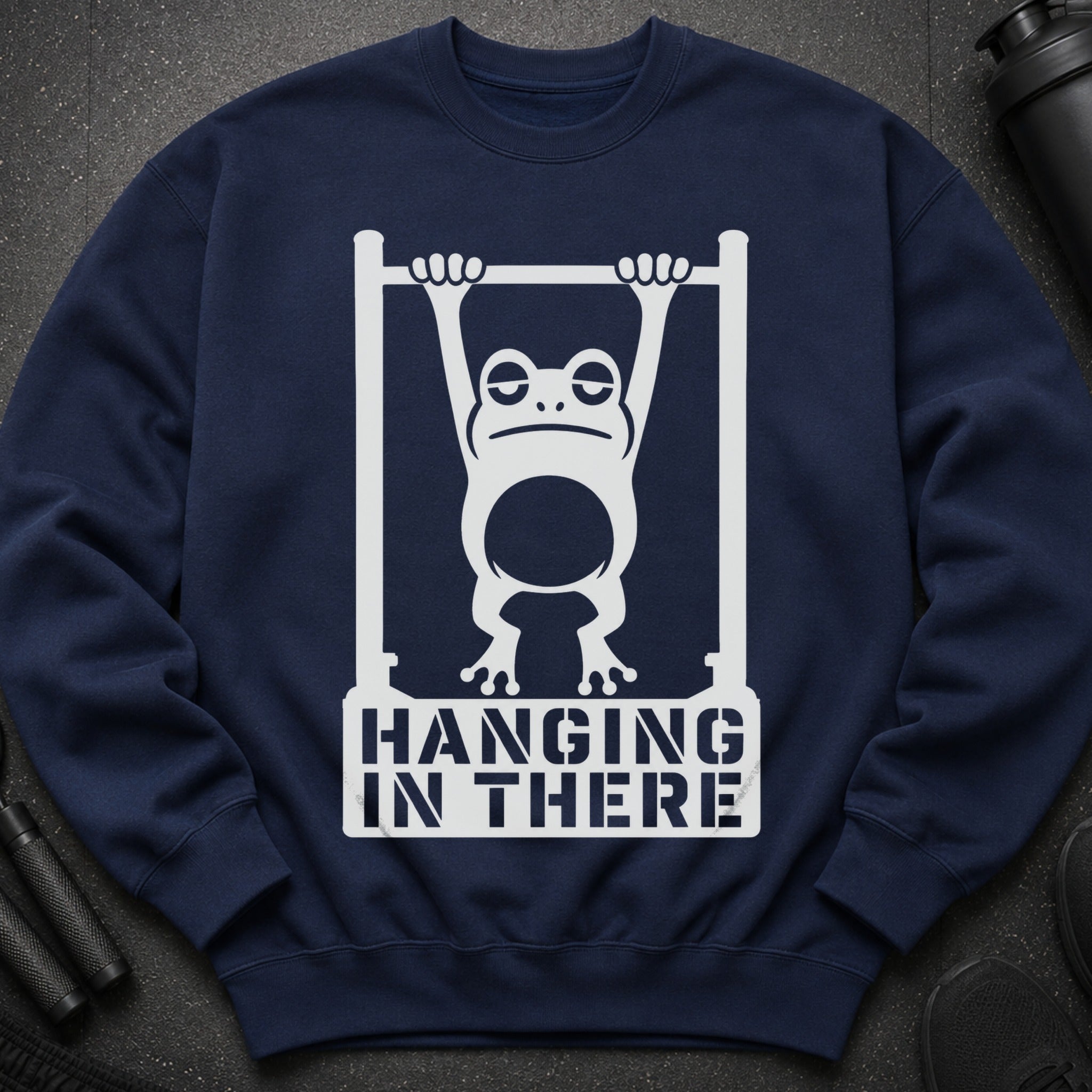 Navy sweatshirt with white graphic of a frog hanging from bars, saying "Hanging In There".