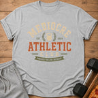Grey t-shirt with "Mediocre Athletic Club" and "Proudly Below Average" text and kettlebell graphic.