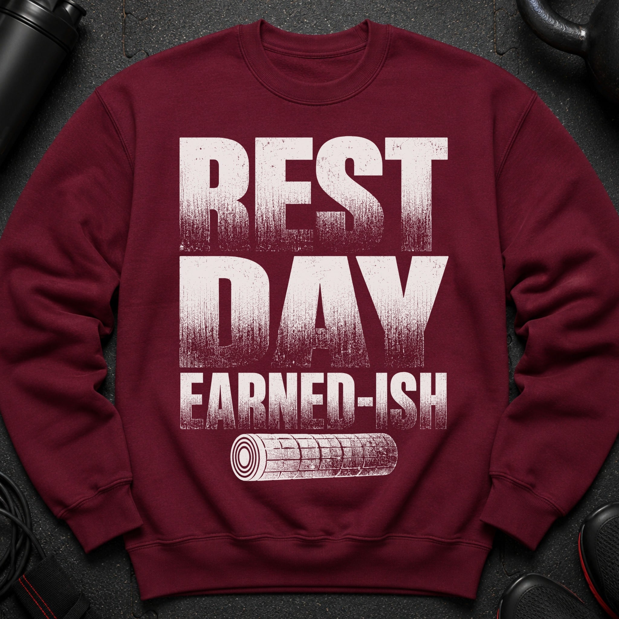 Maroon sweatshirt with "REST DAY EARNED-ISH" text and a rolled gym mat icon.