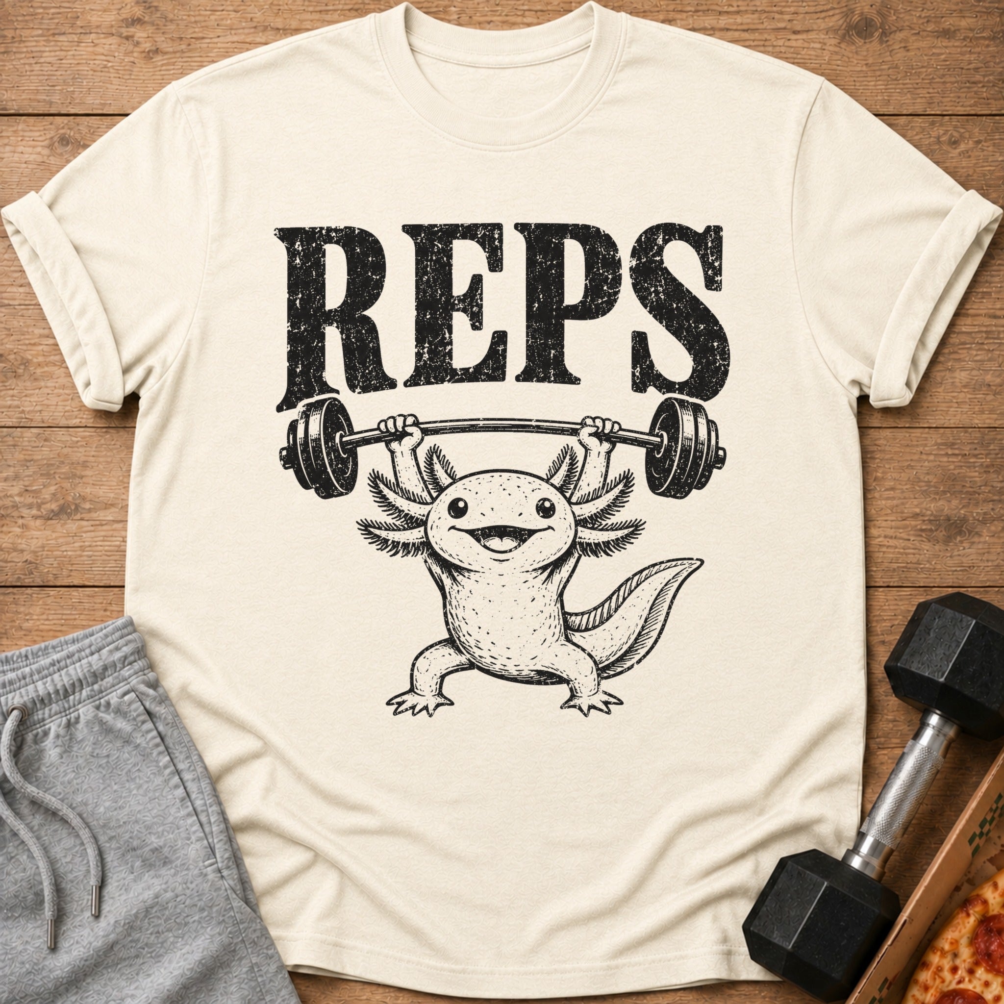 Axolotl lifting weights with "REPS" text on a cream t-shirt.