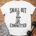 White t-shirt with a meerkat holding a barbell and the text "SMALL BUT COMMITTED."
