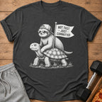 Sloth riding turtle with flag that reads "Not Fast – Just – Committed".