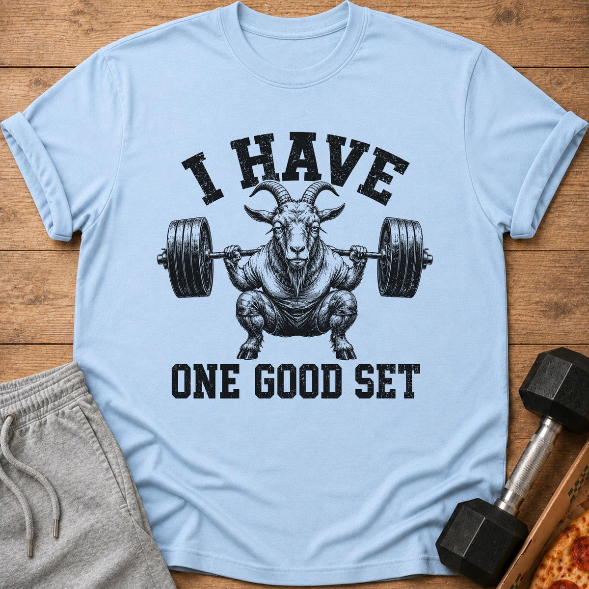 Light blue t-shirt with graphic of a goat squatting with a barbell and text "I HAVE ONE GOOD SET".