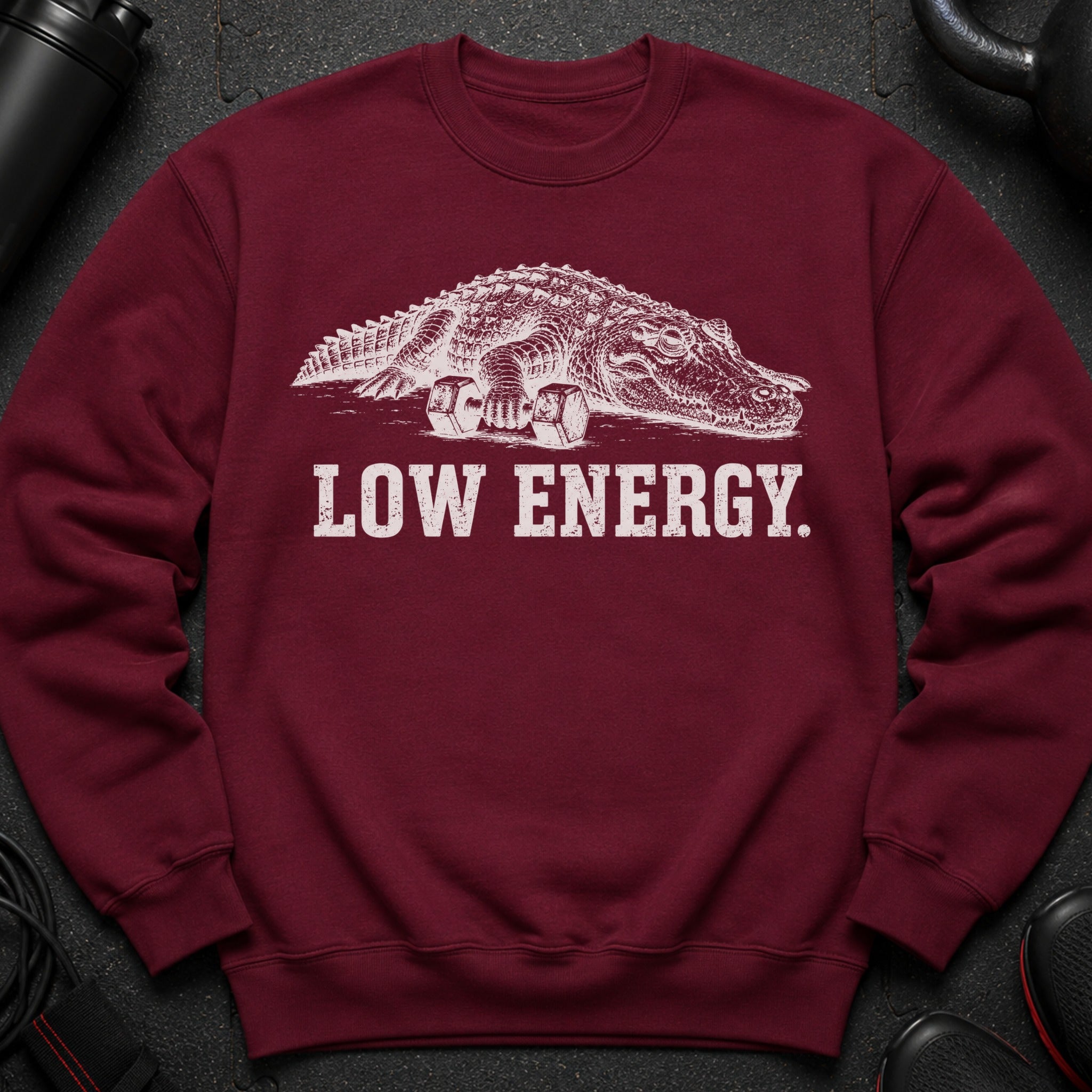 Maroon sweatshirt with white graphic of alligator holding dumbbells and text "LOW ENERGY."