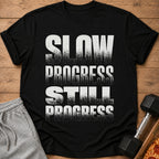 Black t-shirt with distressed white text reading "SLOW PROGRESS STILL PROGRESS".