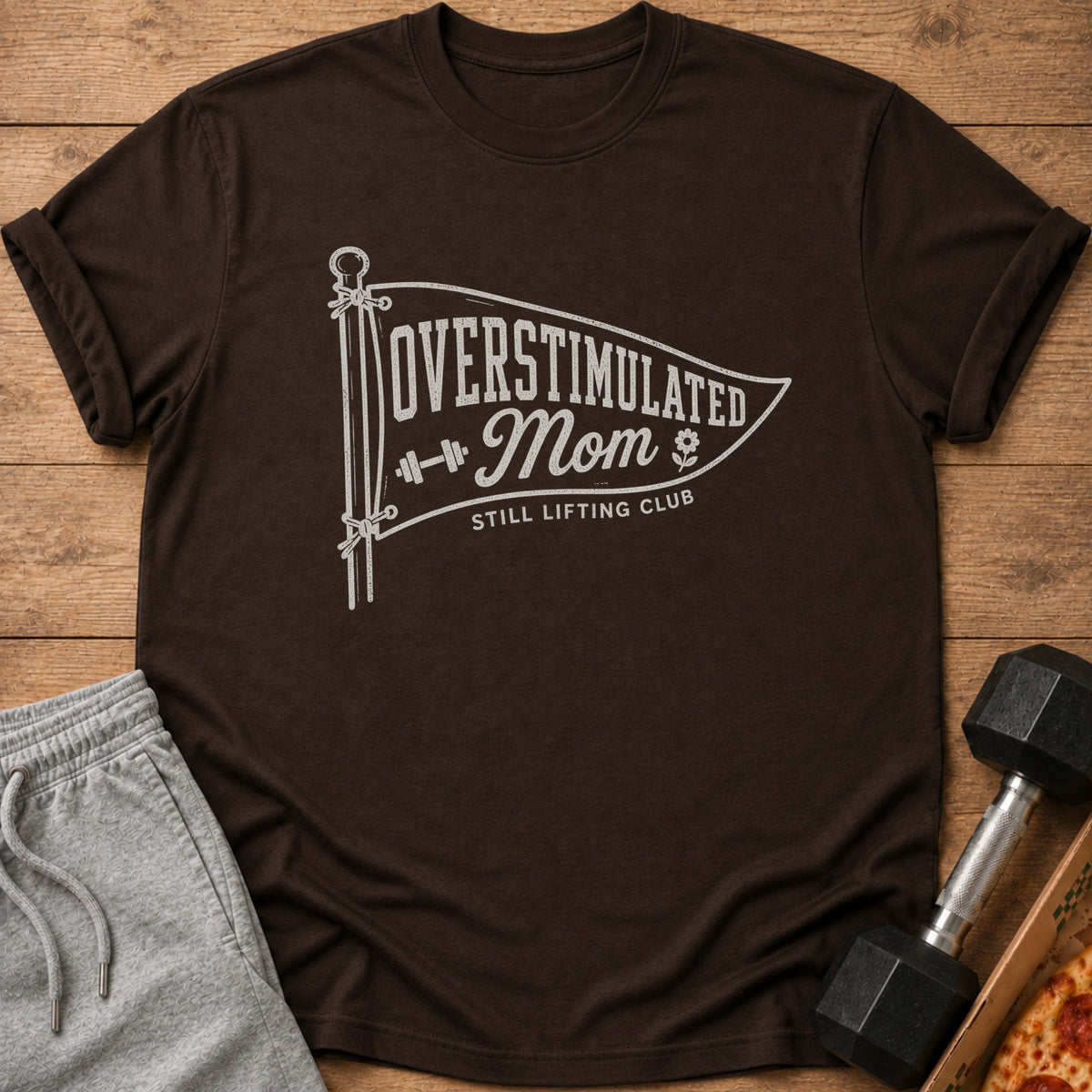 Brown t-shirt with "Overstimulated Mom Still Lifting Club" graphic.
