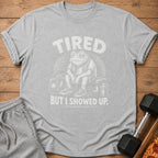 Grey t-shirt with distressed print of a tired frog in gym clothes, text says "TIRED BUT I SHOWED UP".