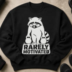 Black sweatshirt with a white graphic of a raccoon holding dumbbells and text that reads "RARELY MOTIVATED."