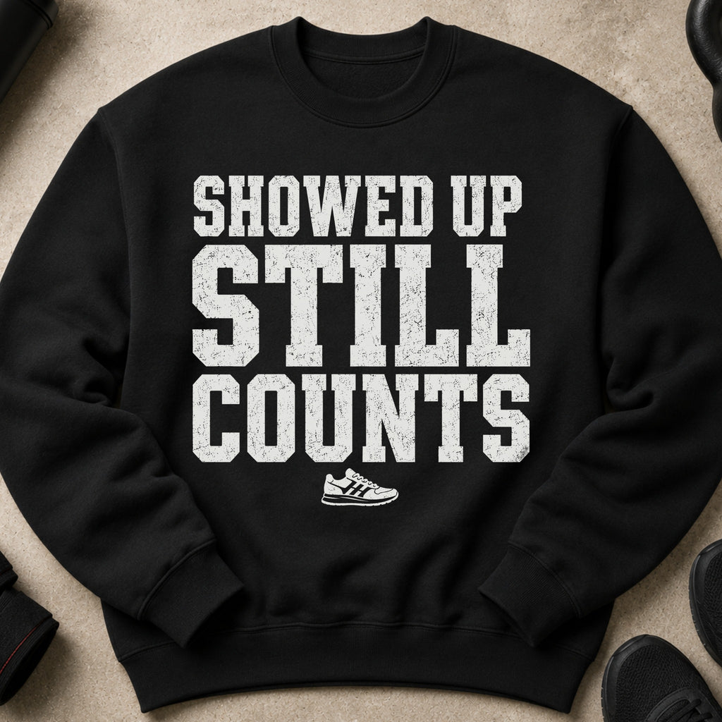 Black sweatshirt with white distressed text "SHOWED UP STILL COUNTS" and a sneaker graphic.