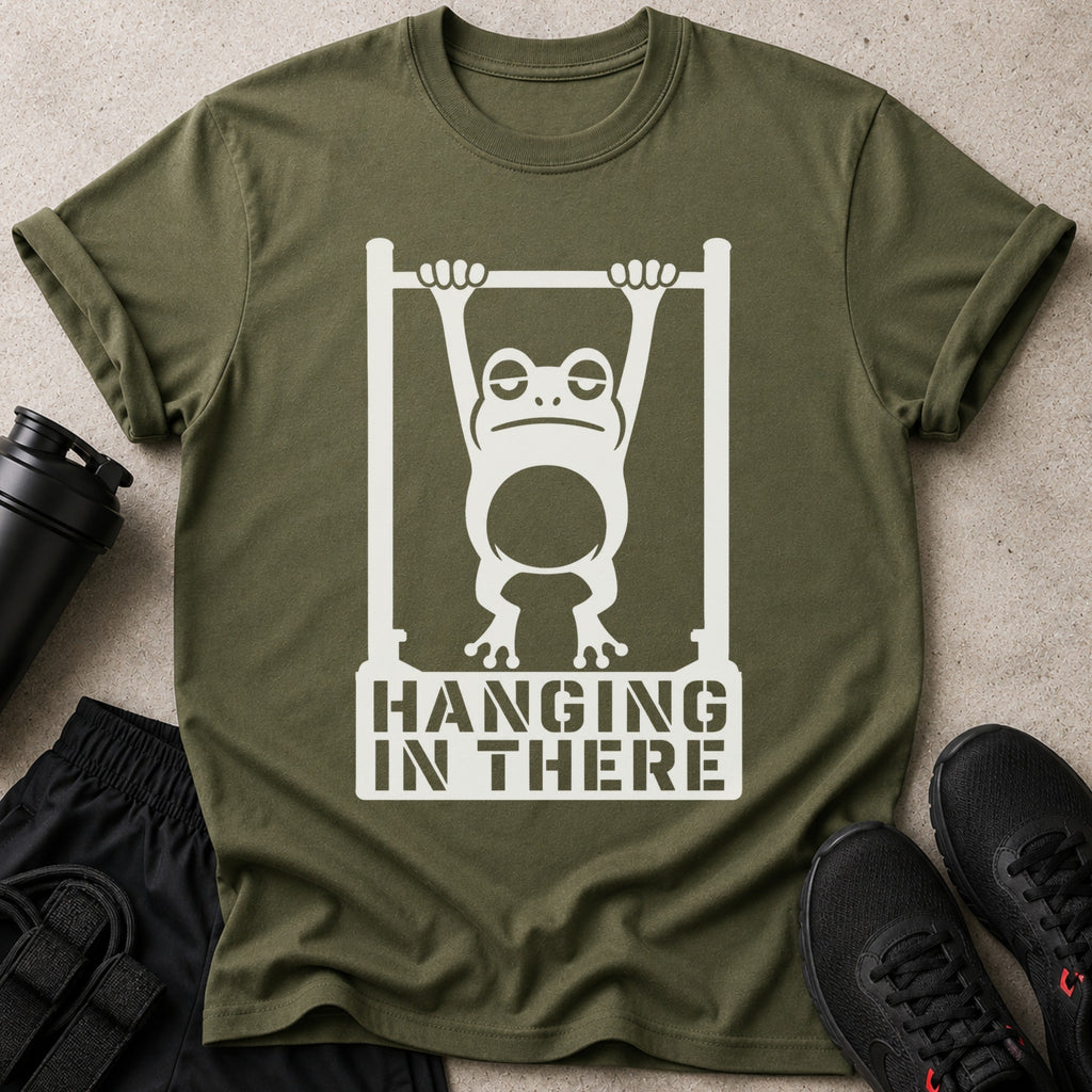 Green t-shirt with a white graphic of a tired frog hanging on a bar with text "HANGING IN THERE".