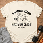 Cream t-shirt with a snail lifting a dumbbell and text "MINIMUM MOTION MAXIMUM CREDIT".