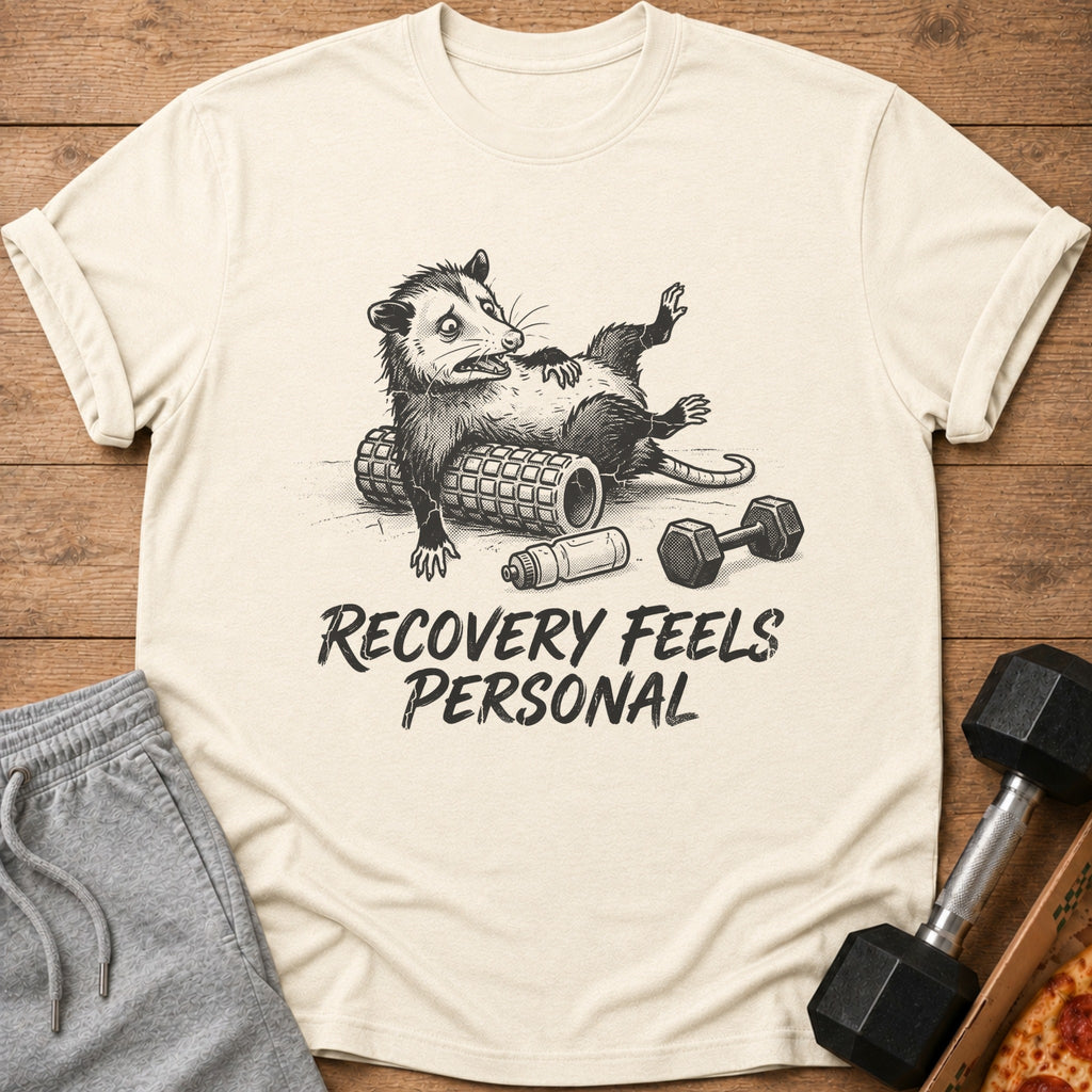 T-shirt with opossum on foam roller, dumbbell, water bottle, and text "RECOVERY FEELS PERSONAL".