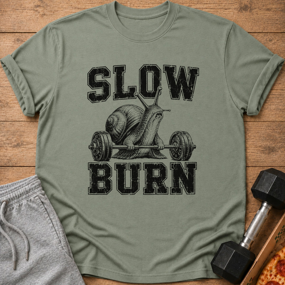 T-shirt with black text "SLOW BURN" and a snail lifting weights.