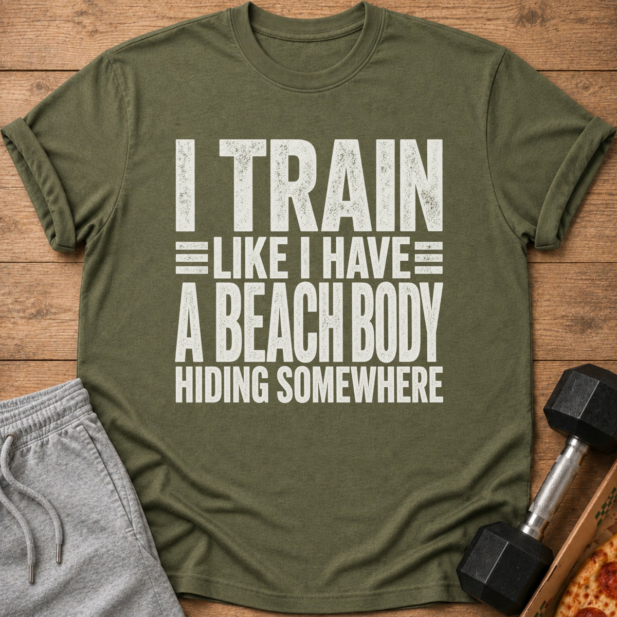 Green t-shirt with white text reading "I TRAIN LIKE I HAVE A BEACH BODY HIDING SOMEWHERE".