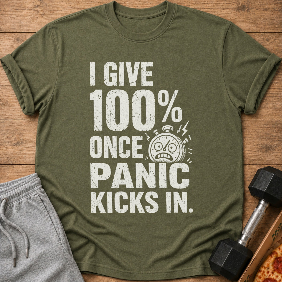 Green t-shirt with white text "I GIVE 100% ONCE PANIC KICKS IN" and a stopwatch graphic.