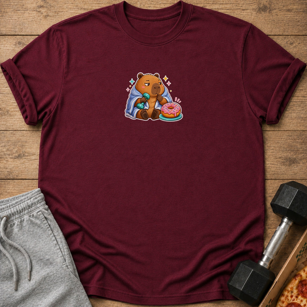 Maroon t-shirt with a cartoon capybara holding a dumbbell and a donut.