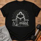Black t-shirt with a white graphic of a hooded figure sitting on a bench with a gym bag.