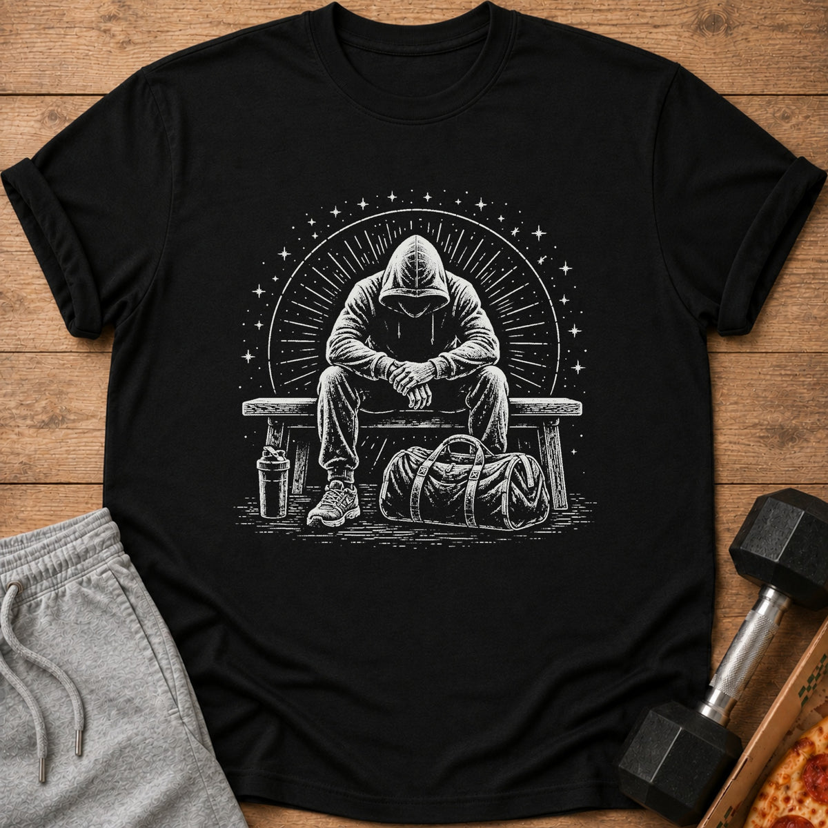 Black t-shirt with a white graphic of a hooded figure sitting on a bench with a gym bag.