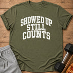 Green t-shirt with white text that reads "SHOWED UP STILL COUNTS".