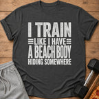 Dark grey t-shirt with "I TRAIN LIKE I HAVE A BEACH BODY HIDING SOMEWHERE" text.
