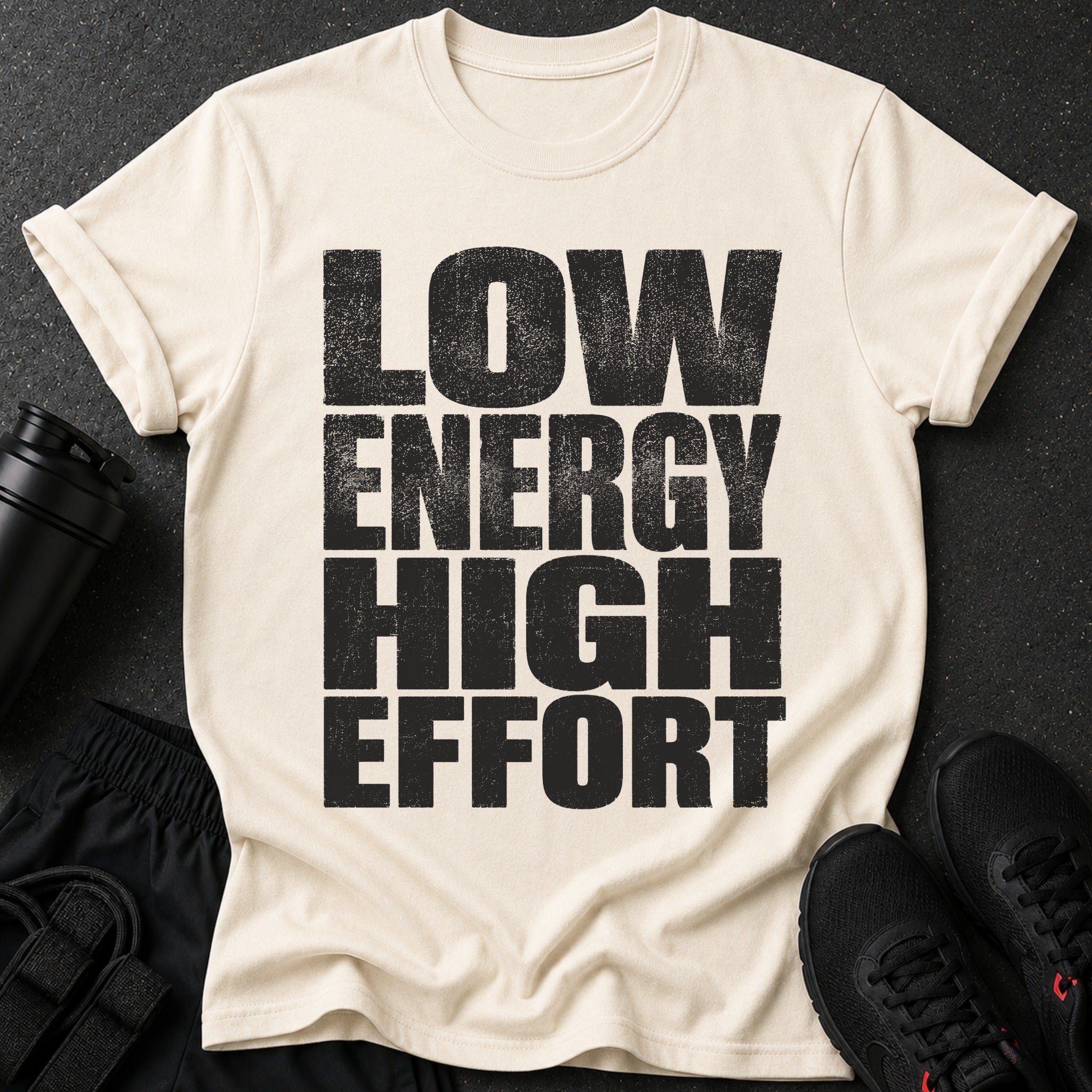 Cream t-shirt with black text "LOW ENERGY HIGH EFFORT" and workout gear.