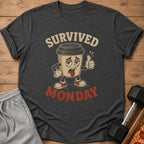 Dark grey t-shirt with cartoon coffee cup saying "SURVIVED MONDAY"
