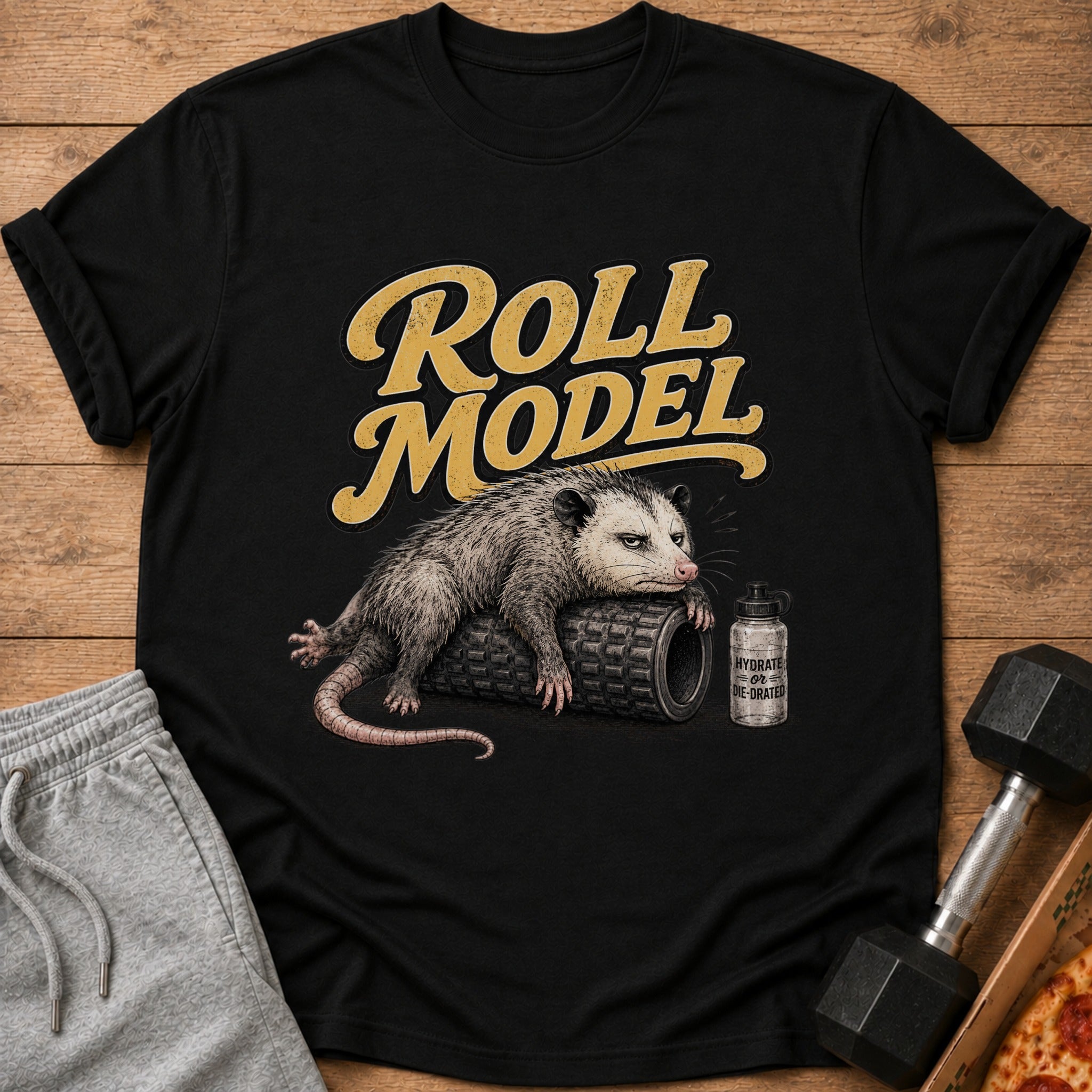 Black t-shirt with a possum lying on a foam roller and a bottle that reads "HYDRATE OR DIE-DRATED".