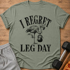 Green t-shirt with flamingo holding a kettlebell and text "I regret leg day."