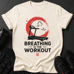 Light tan t-shirt with treadmill graphic and text "BREATHING IS THE WORKOUT".