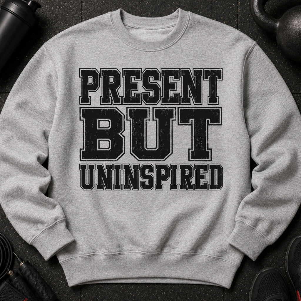 Light grey sweatshirt with black text reading "PRESENT BUT UNINSPIRED".