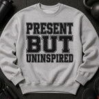 Light grey sweatshirt with black text reading "PRESENT BUT UNINSPIRED".