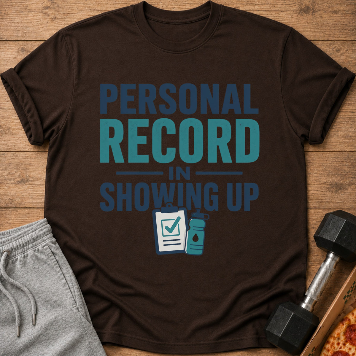 Brown t-shirt with "Personal Record In Showing Up" text and workout icons.