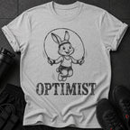 Rabbit jumping rope with "OPTIMIST" text on gray t-shirt.