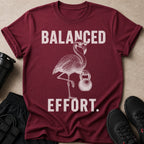T-shirt with distressed graphic of a flamingo wearing glasses holding a kettlebell with text "BALANCED EFFORT."