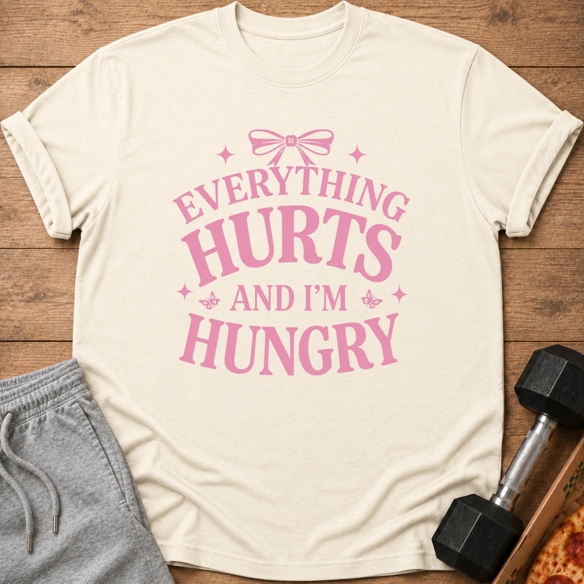 Cream t-shirt with pink text "Everything Hurts And I'm Hungry" and a bow.