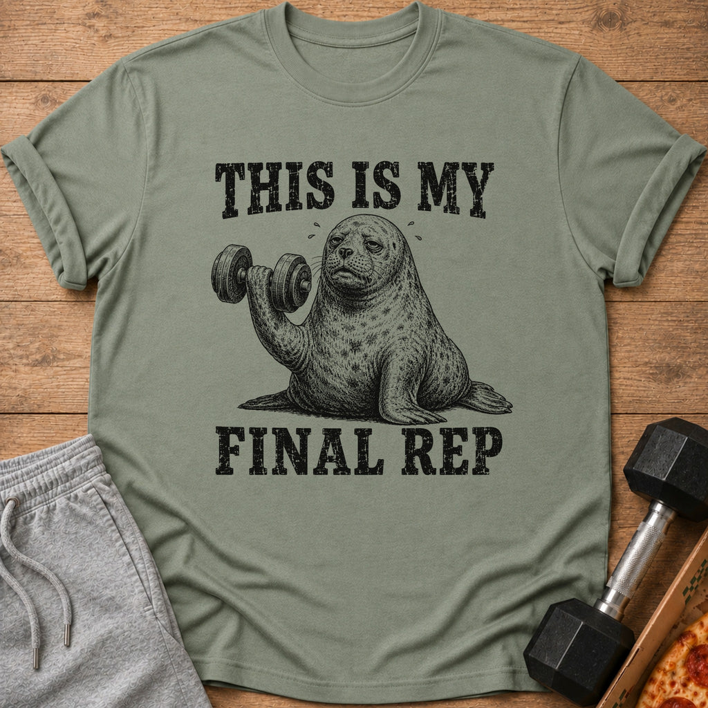 A muted green t-shirt with a graphic of a sweating seal lifting a dumbbell and text reading "THIS IS MY FINAL REP."