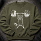 Green sweatshirt with a white outline illustration of a raccoon lifting a barbell.