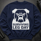 Navy sweatshirt with a white bulldog graphic and "Surviving Leg Day" text.