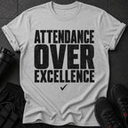 Grey t-shirt with black text "ATTENDANCE OVER EXCELLENCE" and a checkmark.