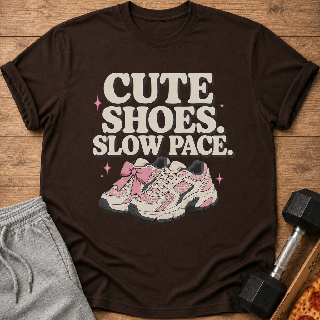 Brown t-shirt with pink sneakers, bow, and "Cute Shoes. Slow Pace." text.