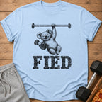 Light blue t-shirt with a koala holding a barbell and dumbbells, with text "FIED".