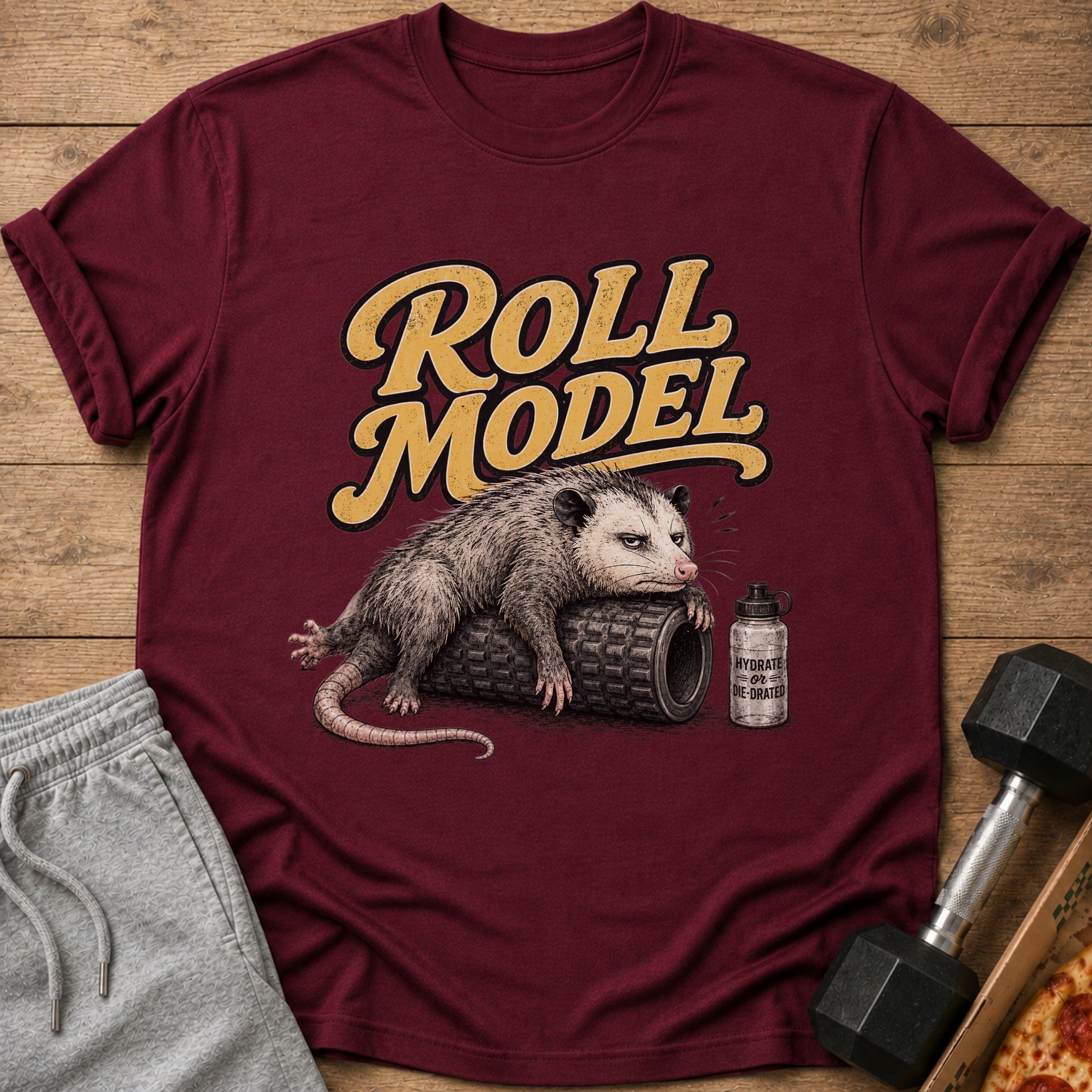 Maroon t-shirt with a possum on a foam roller and text "Roll Model".