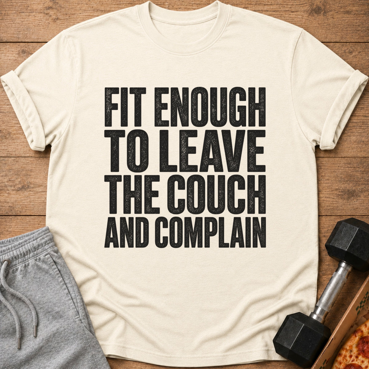 Cream t-shirt with black text reading "FIT ENOUGH TO LEAVE THE COUCH AND COMPLAIN".
