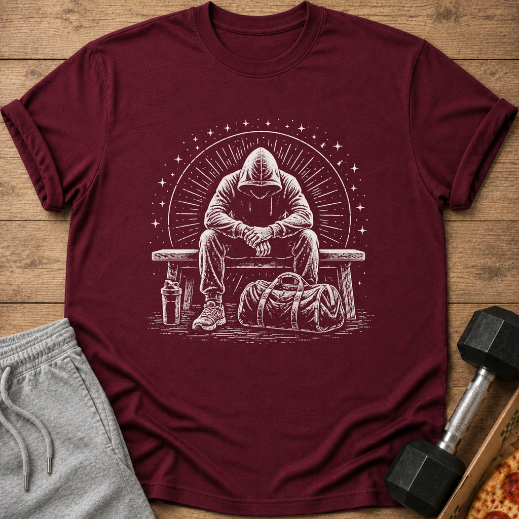 Maroon t-shirt with white graphic of a person in a hood sitting on a bench with a gym bag.