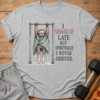 Grey t-shirt with a sloth on a pull-up bar and text "I showed up late but spiritually I never arrived."