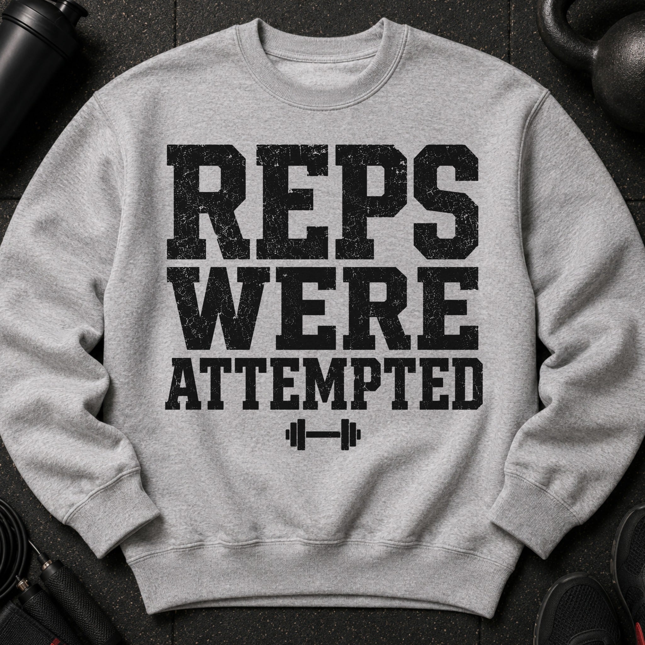 Grey sweatshirt with distressed text "REPS WERE ATTEMPTED" and a dumbbell graphic.