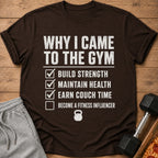 Brown t-shirt with text listing gym reasons: build strength, maintain health, earn couch time.