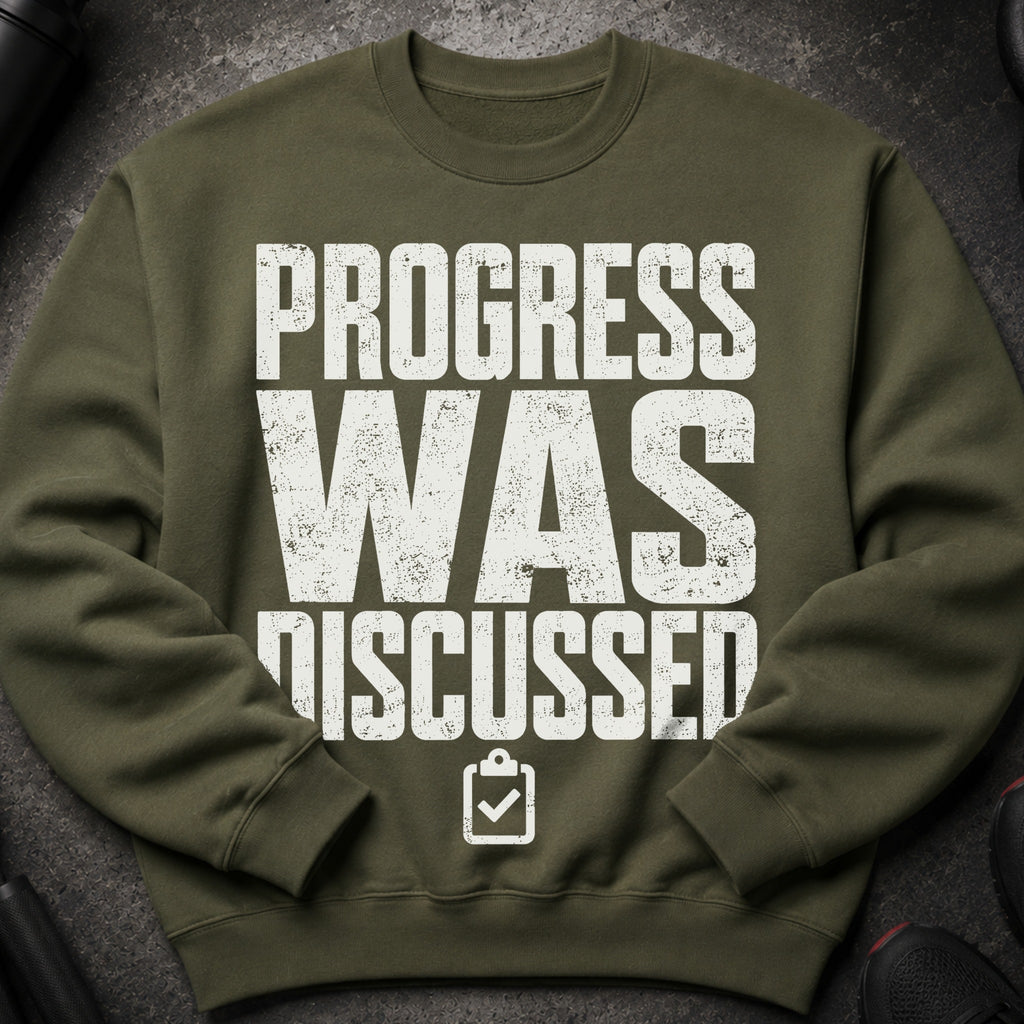 Green sweatshirt with distressed white text "PROGRESS WAS DISCUSSED".